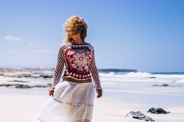Mooie hippie chique mode vrouw met lange blonde krullend haar buiten genieten van het strand in de zomer vakantie  - Foto, afbeelding