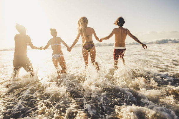 Defocated voor actieve en bewegingsconcept mensen hebben plezier lopen in het zeewater tijdens de zomervakantie  - Foto, afbeelding