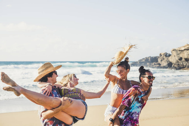 Wesoła grupa ludzi chłopcy i dziewczęta bawią się razem na plaży podczas wakacyjnych wakacji  - Zdjęcie, obraz