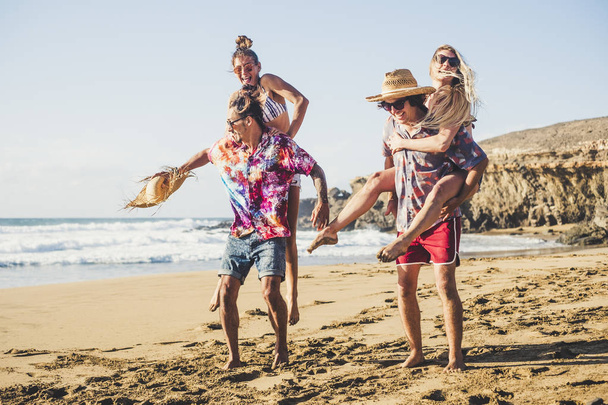 Χαρούμενη ομάδα ανθρώπων αγόρια και κορίτσια διασκεδάζουν μαζί στην παραλία κατά τη διάρκεια των καλοκαιρινών διακοπών  - Φωτογραφία, εικόνα
