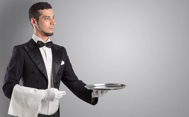 Tarjoilija palvelee valkoiset käsineet ja teräs tarjotin
 - Valokuva, kuva