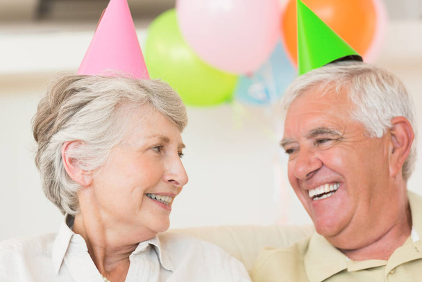 Pareja mayor celebrando un cumpleaños juntos en casa en la sala de estar
 - Foto, Imagen