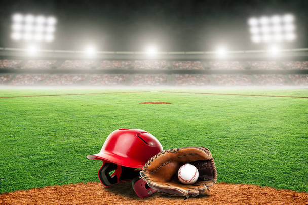 Бейсбольная перчатка, мяч и шлем на поле на открытом стадионе Уит
 - Фото, изображение