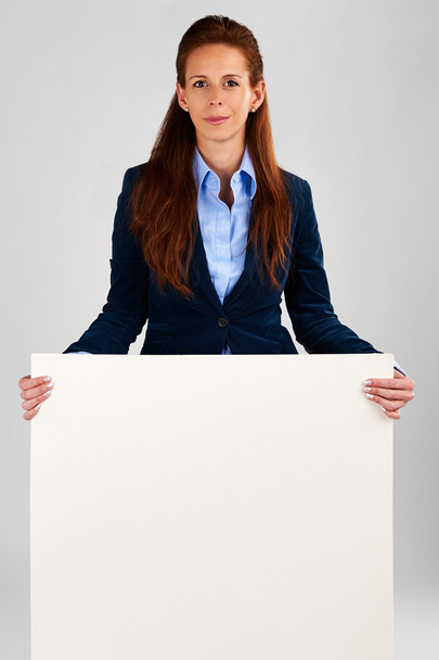 Mujer de negocios exitosa sosteniendo banner blanco vacío
 - Foto, Imagen