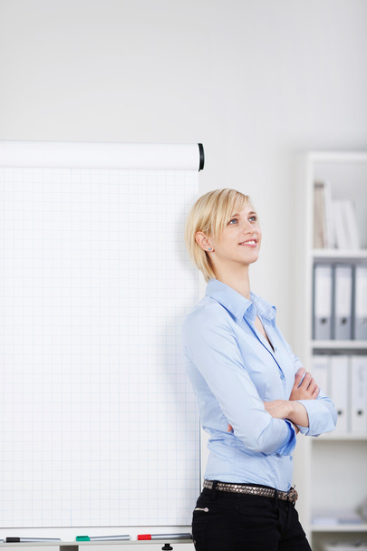 Confident woman leaning against flipchart - Foto, afbeelding