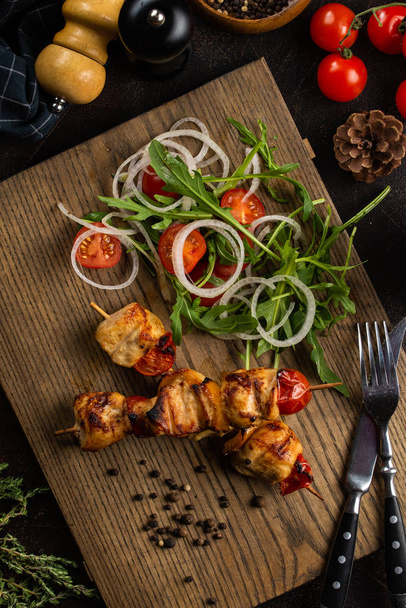 Spiedini di carne alla griglia su tavola di legno con insalata di verdure
 - Foto, immagini