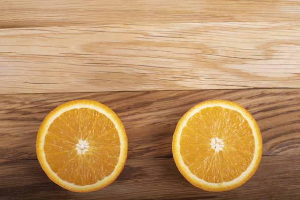 Oranje op een houten plank, in tweeën gesneden - Foto, afbeelding