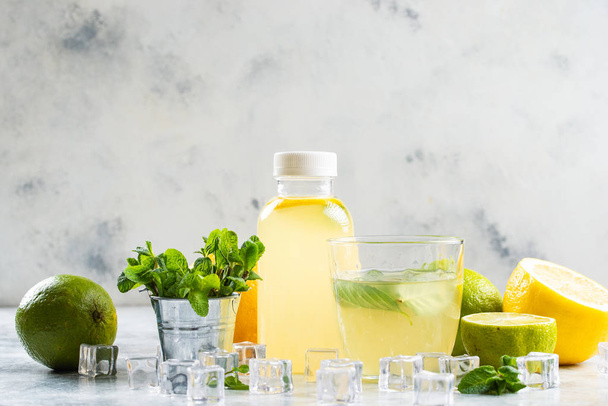 limonata fatta in casa in bottiglia su tavolo bianco con ingredienti
 - Foto, immagini