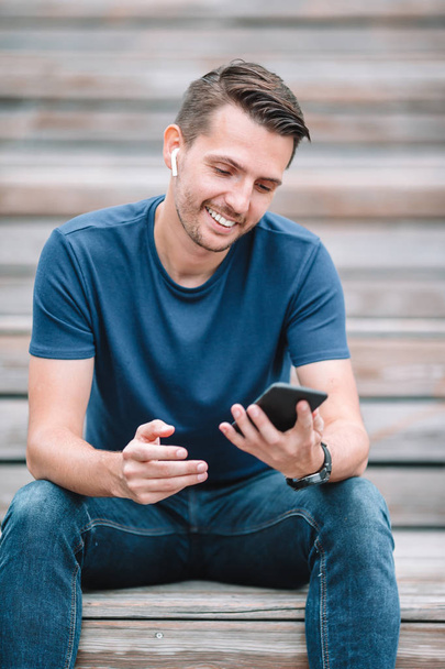 Чоловік читає текстове повідомлення на мобільному телефоні під час ходьби в парку
 - Фото, зображення
