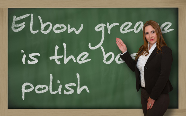 肘グリースを示す先生は黒板に最高のポーランド語です。 - 写真・画像