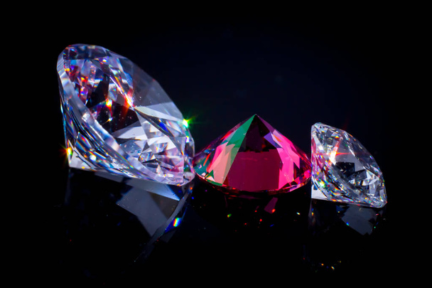 Несколько шикарных кристаллов на поверхности черного зеркала, мерцающие и сверкающие
 - Фото, изображение