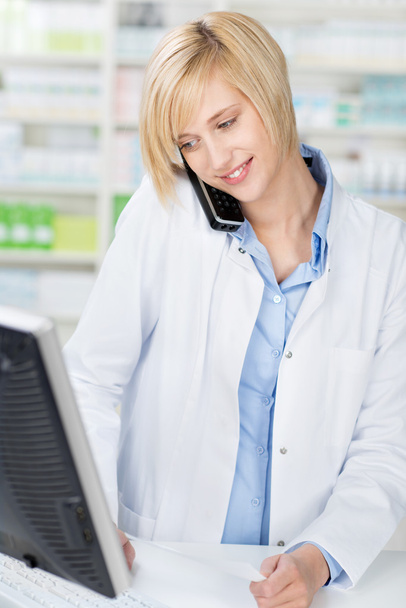 Pharmacist With Prescription Using Cordless Phone While Looking - Foto, Imagem