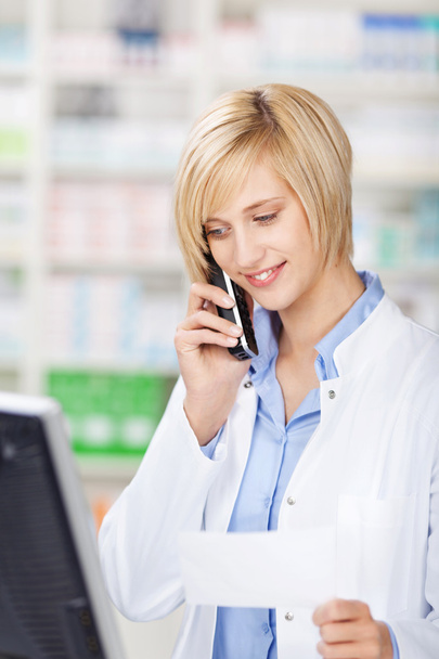 Farmacêutico Segurando Papel Prescrição Enquanto Usando Telefone Sem Fio
 - Foto, Imagem