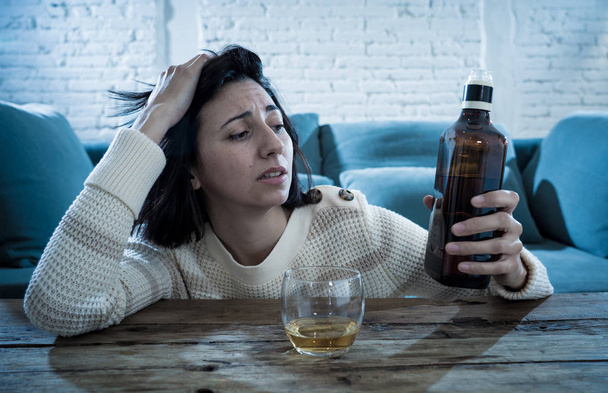 Drunk alcoholic depressed woman drinking scotch whiskey spirits alone at home. Feeling hopeless, week and lonely. In People lifestyle, Depression, alcohol addiction, alcoholism and drug abuse concept. - Foto, Imagen
