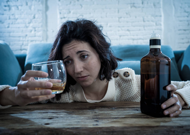 Drunk alcoholic depressed woman drinking scotch whiskey spirits alone at home. Feeling hopeless, week and lonely. In People lifestyle, Depression, alcohol addiction, alcoholism and drug abuse concept. - Photo, Image