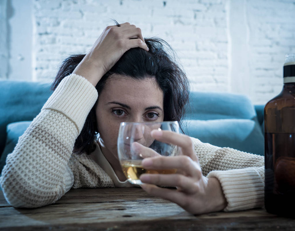 Drunk alcoholic depressed woman drinking scotch whiskey spirits alone at home. Feeling hopeless, week and lonely. In People lifestyle, Depression, alcohol addiction, alcoholism and drug abuse concept. - Foto, imagen