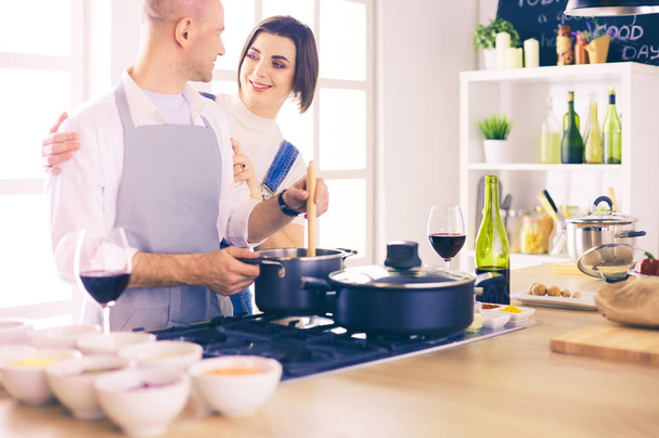 Couple cooking together in the kitchen at home - Photo, image