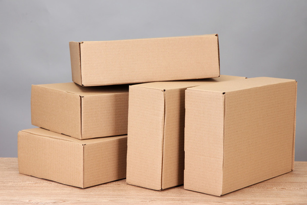 Parcels boxes on wooden table, on grey background - Fotó, kép