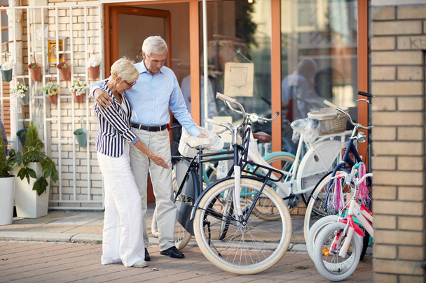 elderly couple buying new bicycle in bike shop - Foto, Bild