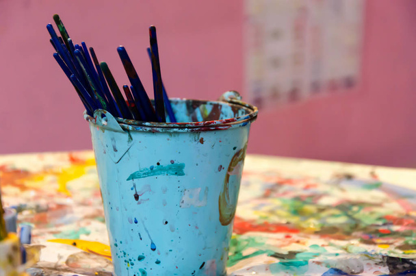 Paint brush in a bucket on the table. - Фото, зображення