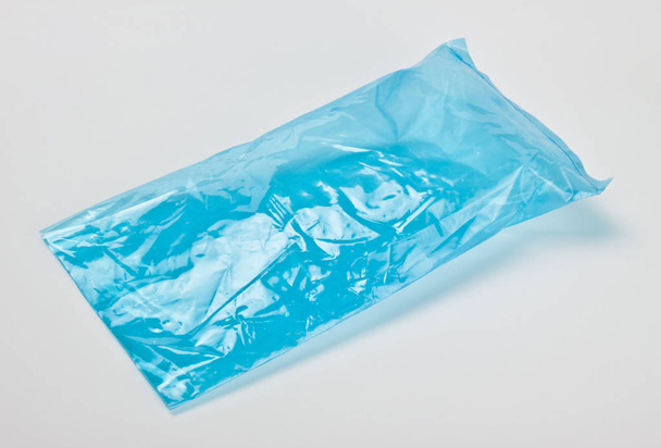 blue empty polyethylene package on grey background - Valokuva, kuva