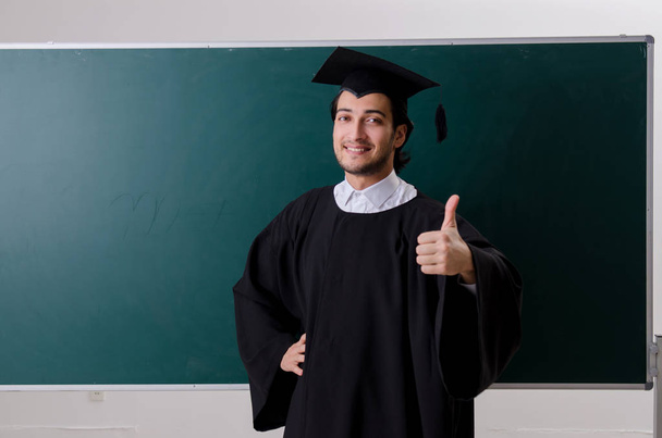 Étudiant diplômé devant le tableau vert  - Photo, image