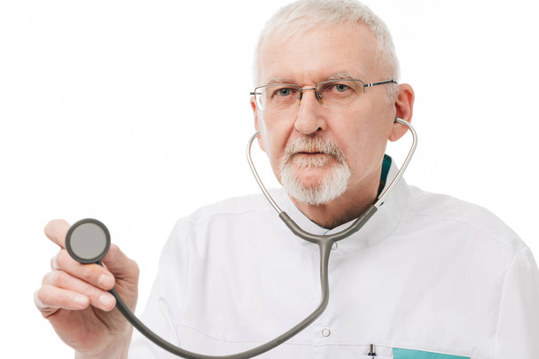 Old doctor with gray hair and beard in eyeglasses and uniform us - 写真・画像