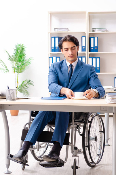 Ofiste çalışan tekerlekli sandalyede erkek çalışan  - Fotoğraf, Görsel