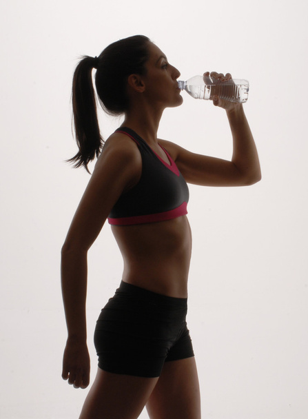 Portrait of young woman wearing sport clothes and drinking water - Foto, Imagem
