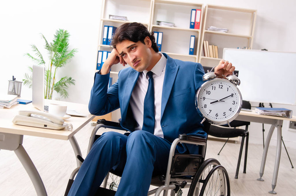 Mężczyzna pracownika na wózku inwalidzkim, pracując w biurze  - Zdjęcie, obraz