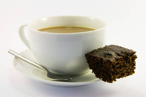 Cup of tea with dark chocolate brownie on a white background - Foto, afbeelding