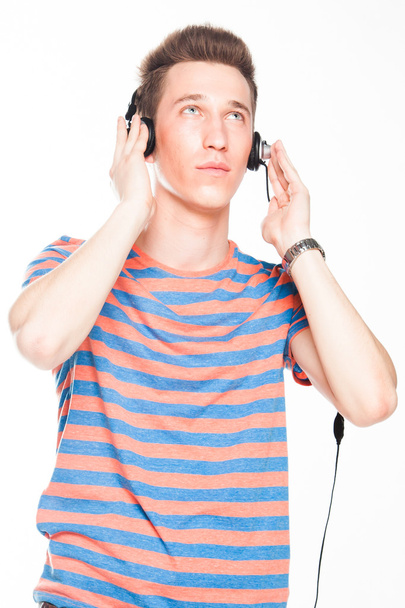 mies kuuntelee musiikkia kuulokkeilla
 - Valokuva, kuva