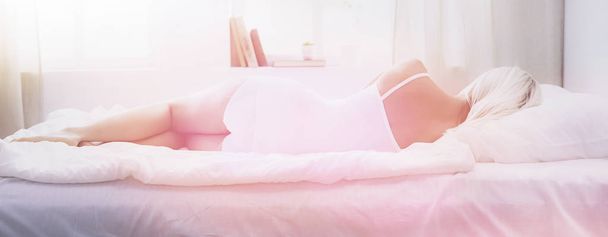 Pretty woman lying down on her bed at home - 写真・画像