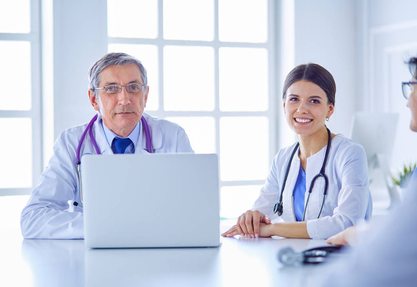 Equipe médica séria usando um laptop em um brilhante consultório - Foto, Imagem