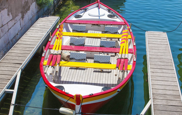 El pequeño y colorido barco estacionado en el muelle de madera
. - Foto, Imagen