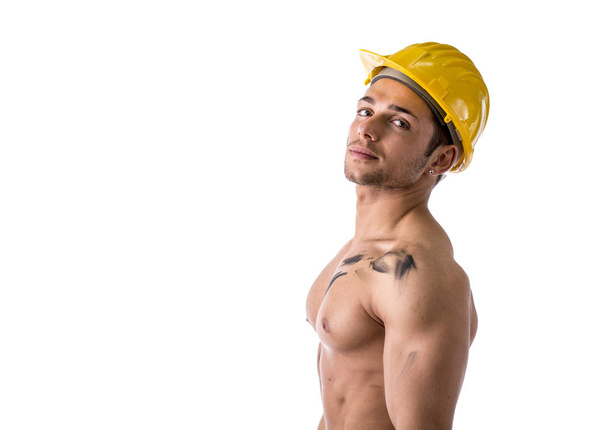 profil görünümü gömleksiz kas genç inşaat işçisi kask giyiyor - Fotoğraf, Görsel