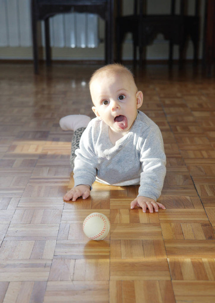 Cute baby girl on the floor playing with small ball - Fotografie, Obrázek
