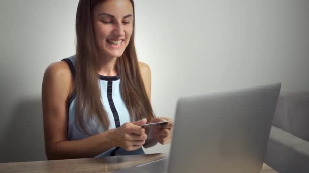 Online vásárlás koncepció. Egy bankkártyával és laptoppal rendelkező nő. nő megcsókolja a hitelkártya - Felvétel, videó