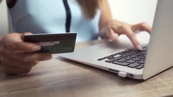 Концепция покупок онлайн. Женщина держит кредитную карту и использует ноутбук
 - Кадры, видео