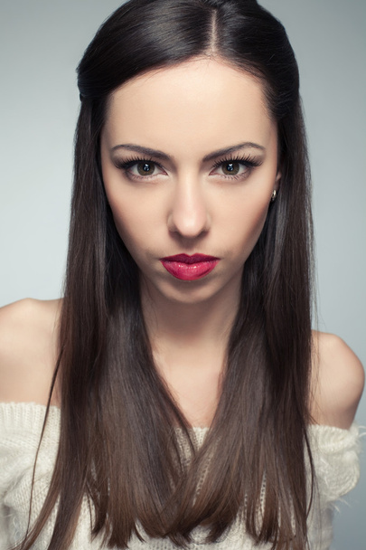Portrait of angry beautiful long-haired brunette posing over lig - Photo, Image