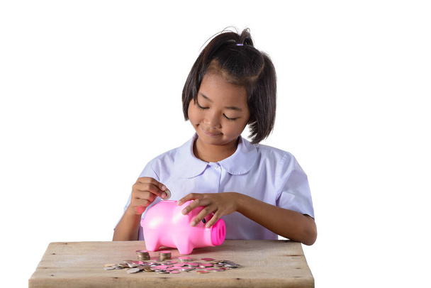 Linda chica asiática poniendo monedas en alcancía aislado en blanco
  - Foto, Imagen