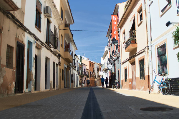 DENIA, SPAIN - OCTOBER 7, 2018: Narrow Spanish street in the old town of Denia - Фото, изображение