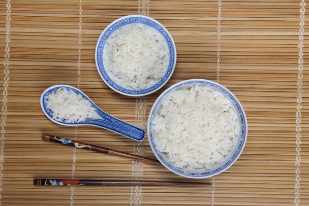 bols of rice on bamboo background  - Фото, изображение
