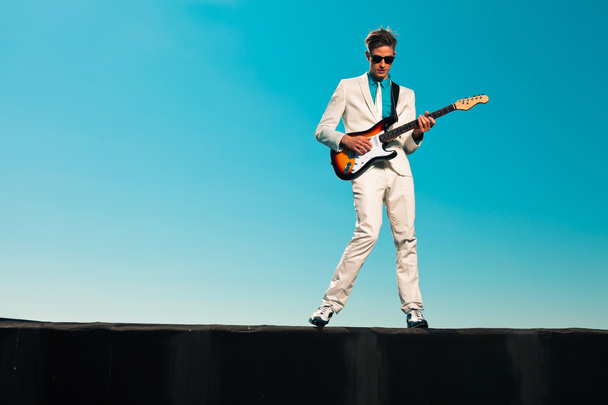 Vintage fifties male guitar player with white suit and sunglasse - Photo, Image