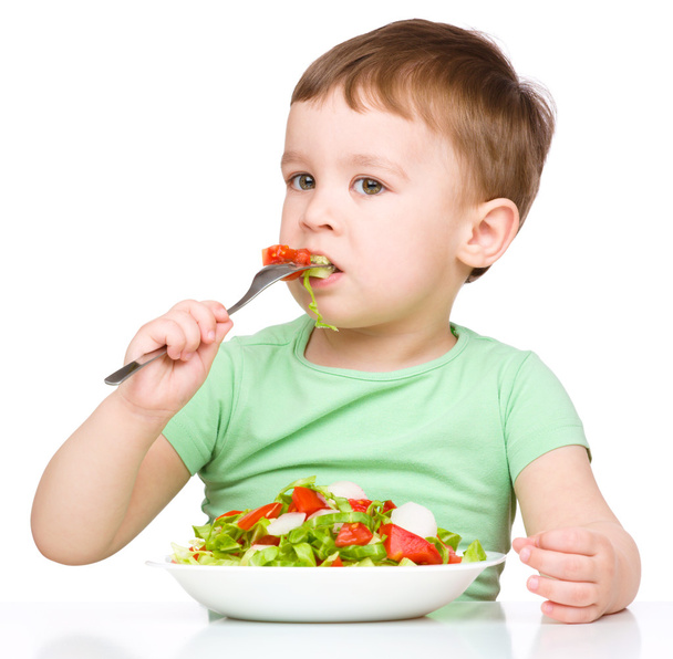 Cute little boy is eating vegetable salad - Foto, Imagen