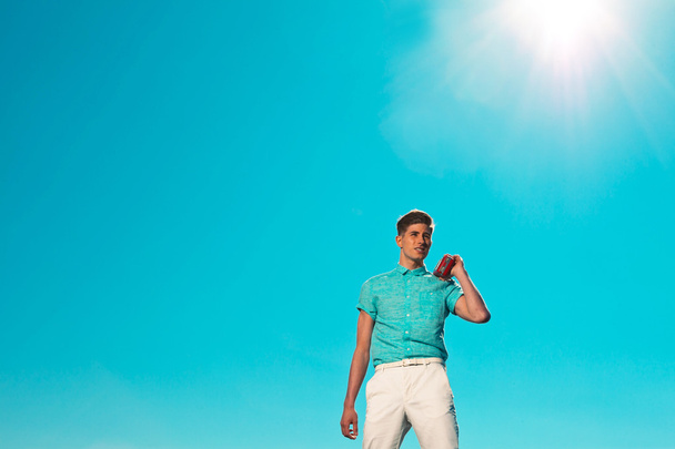 Retro fifties summer fashion man in blue shirt listens to portab - Foto, imagen