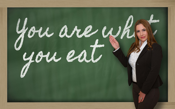 Profesor mostrando Usted es lo que come en pizarra
 - Foto, Imagen