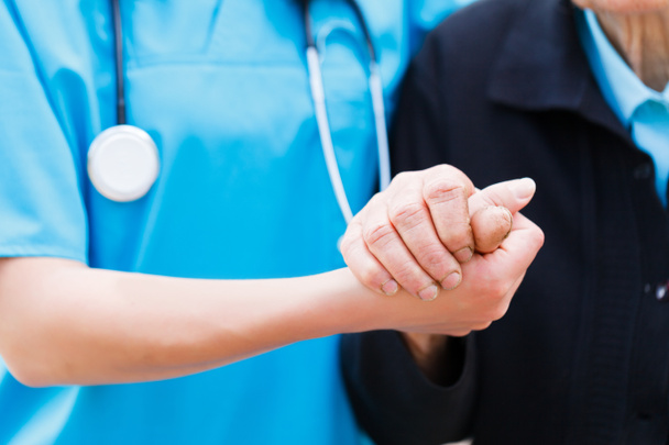 Caring Nurse holding Elderly Hands - Photo, Image
