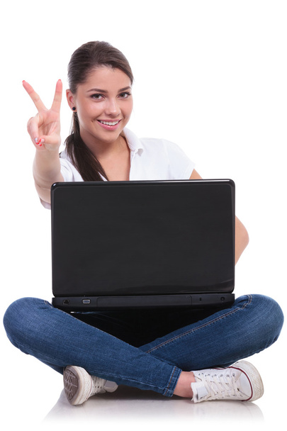 Casual vrouw zit met laptop & overwinning - Foto, afbeelding
