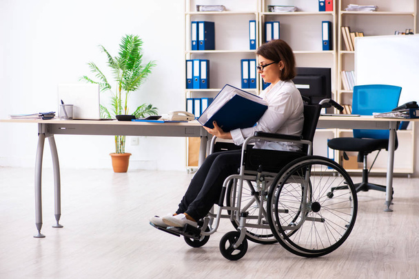 Pyörätuolissa oleva naispuolinen työntekijä toimistossa   - Valokuva, kuva